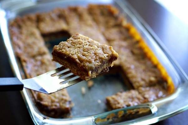Chocolate caramel oatmeal bars on a spatula.