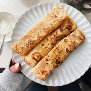 French toast crepes rolled on a plate.