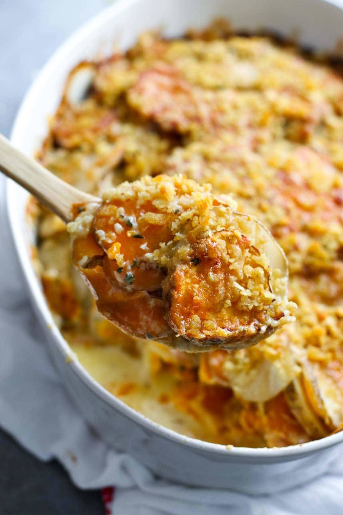 Garlic Herb Cheesy Potatoes on a wooden spoon.