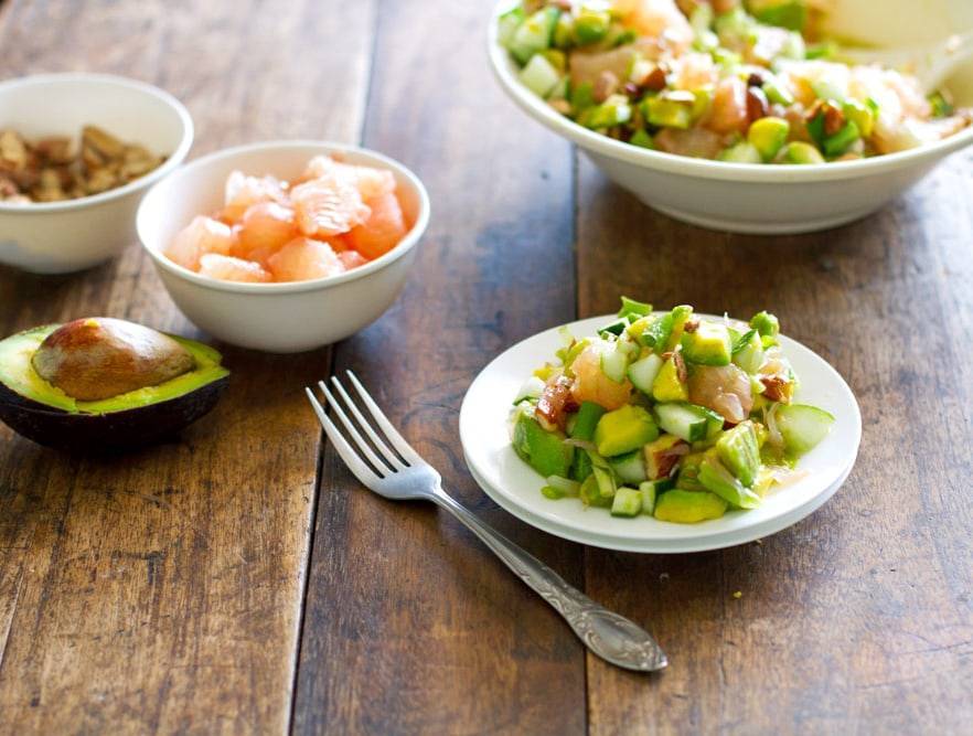Avocado cucumber grapefruit salad on a plate.