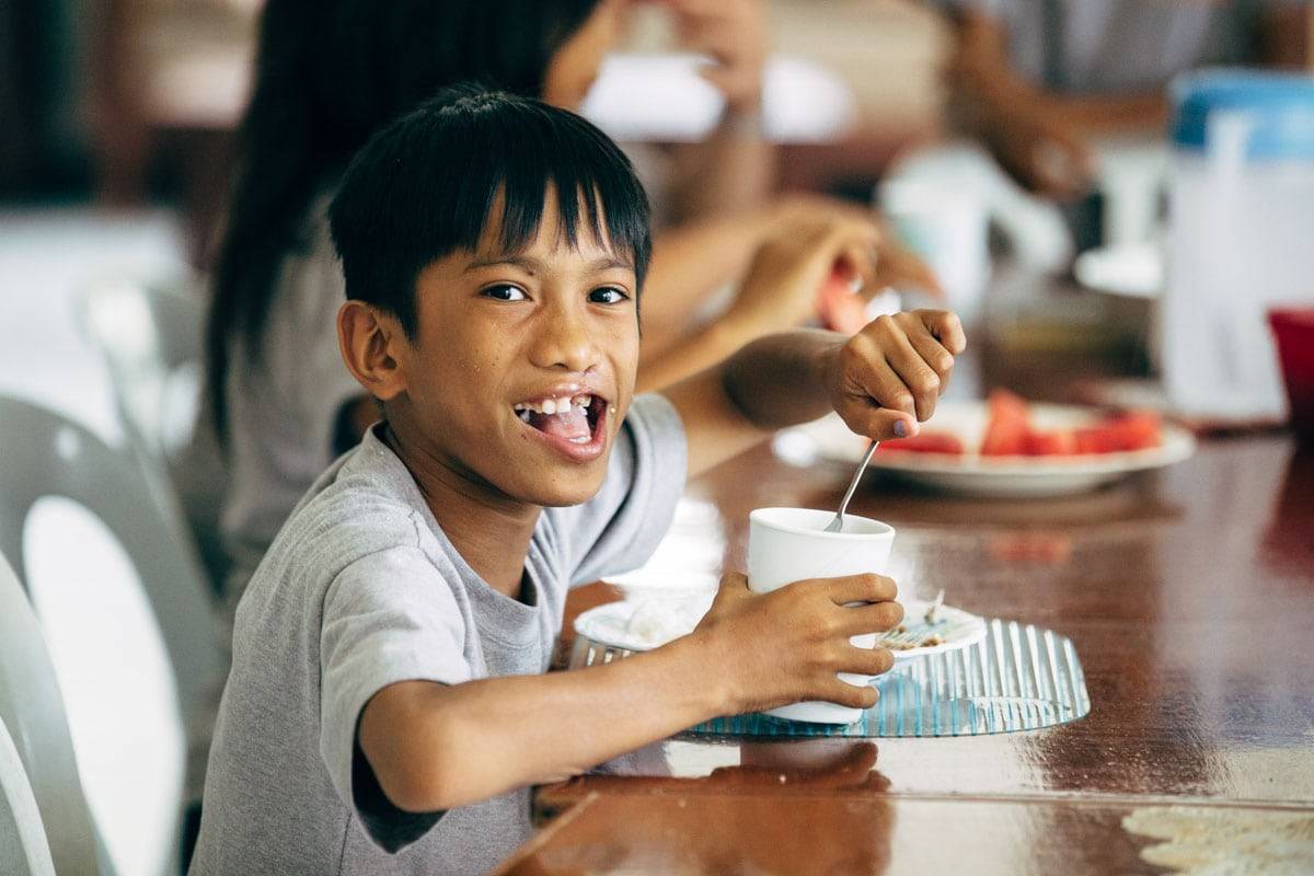 Young boy eating at a table.