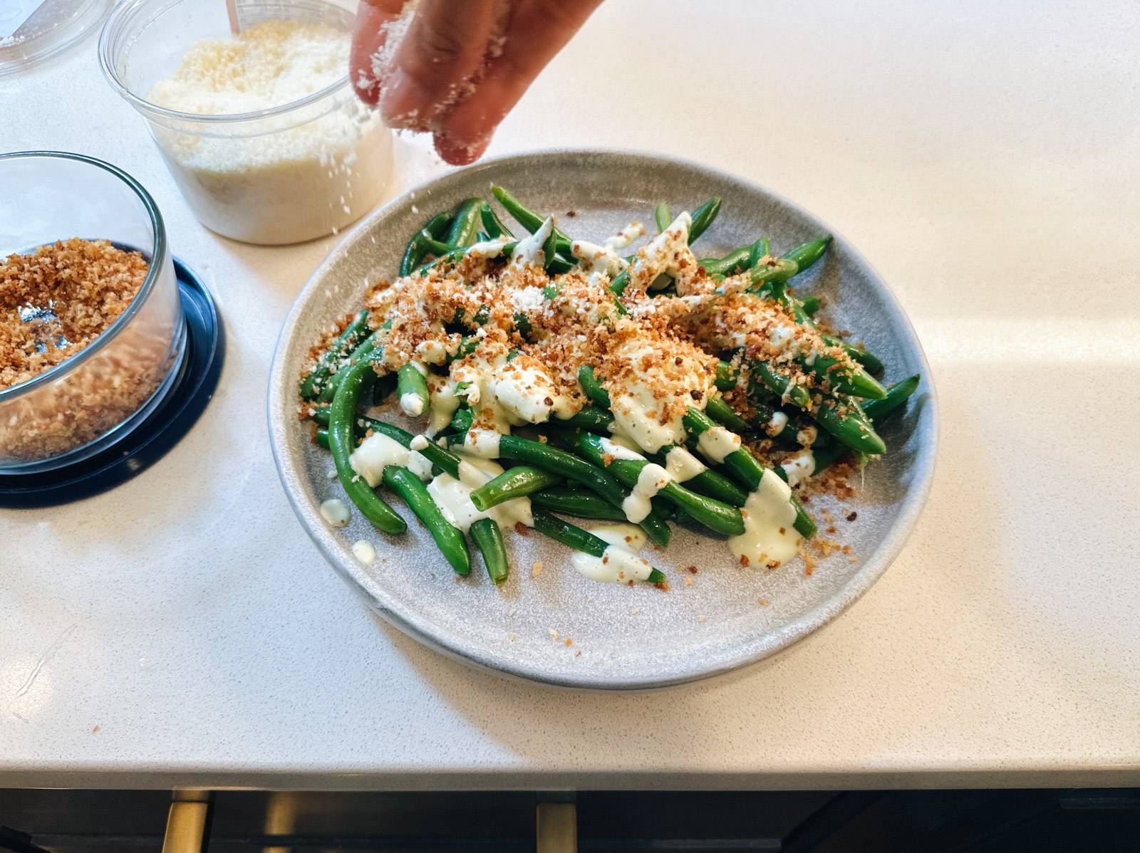 Sprinkling panko on green beans.