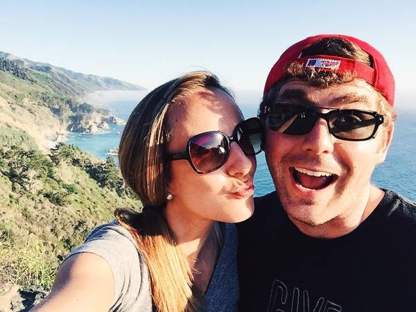 Man and woman wearing sunglasses making silly faces.