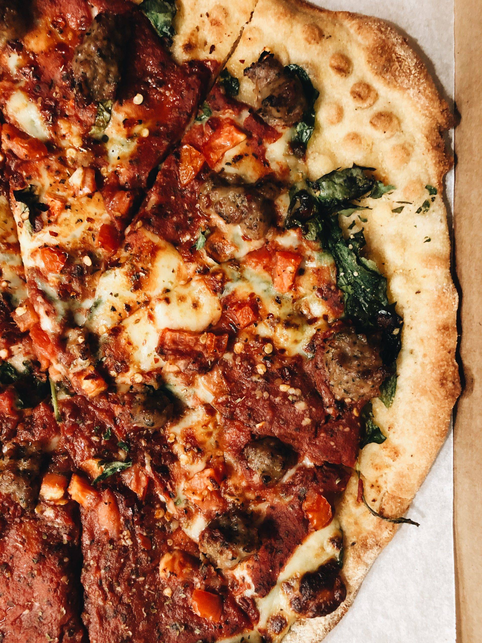 Close up shot of a delicious looking pizza with cheese and meatballs on top.