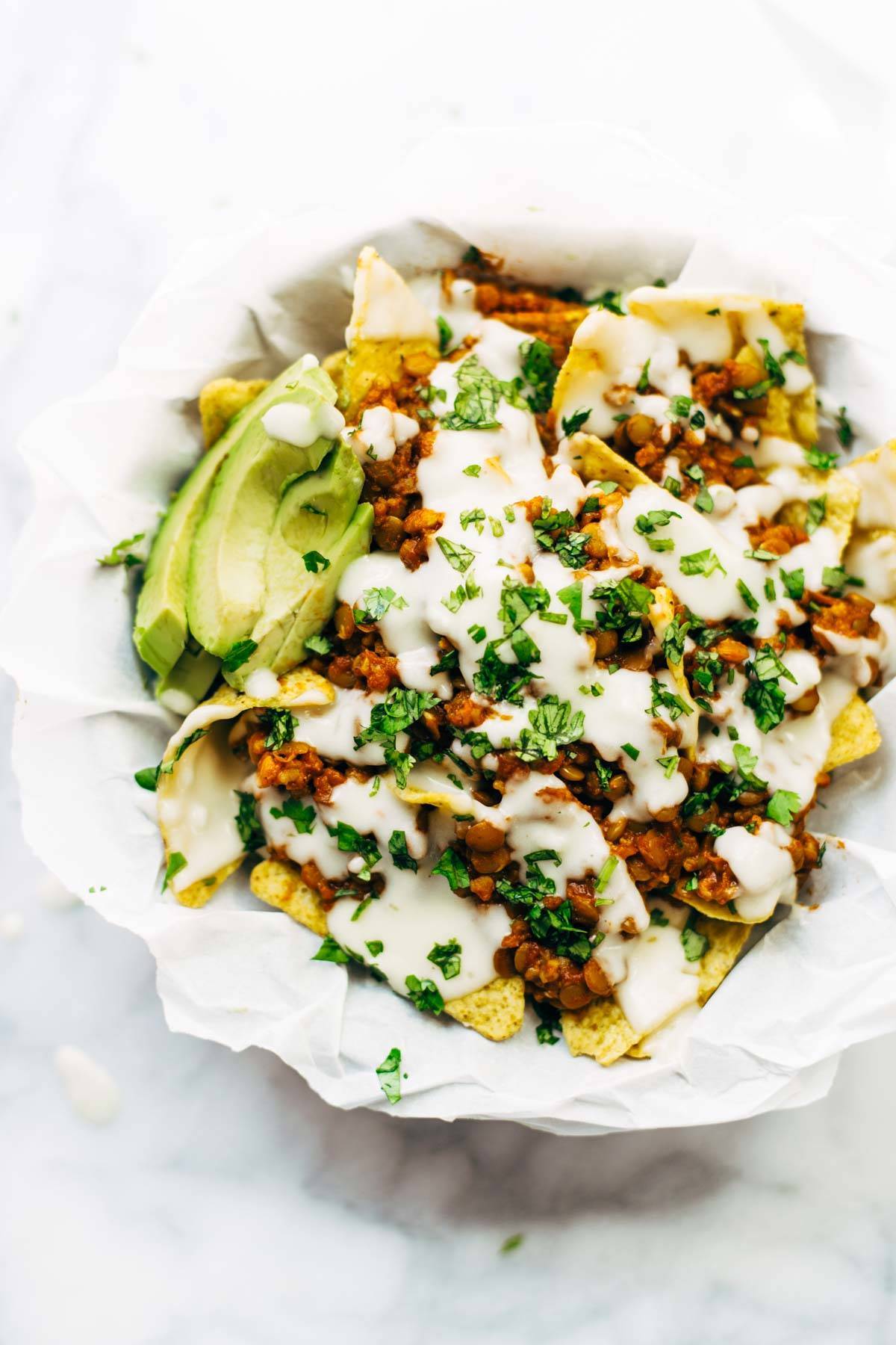 Spicy Lentil Nachos with Three Cheese Sauce - you will not believe how good these are! Saucy filling with a velvety homemade cheese sauce. Vegetarian. | pinchofyum.com